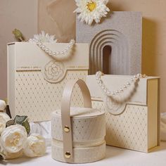 three bags, one with pearls and the other with flowers on it are sitting next to each other