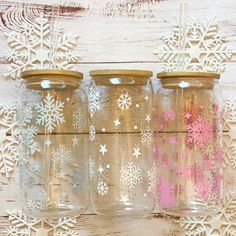 three glass jars with snowflakes painted on them