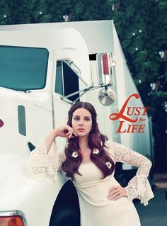 a woman in a white dress leaning against a semi truck with the words just for life written on it