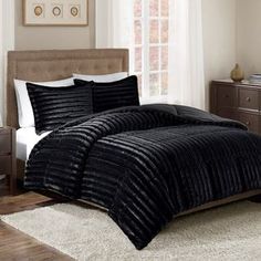 a bed in a bedroom with brown comforter and pillows