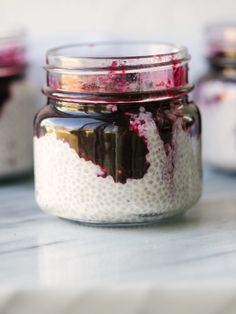 three jars filled with food sitting on top of a white counter next to each other