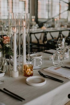 the table is set with candles, place settings and menus for dinner or wedding guests