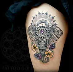 an elephant tattoo on the thigh with flowers