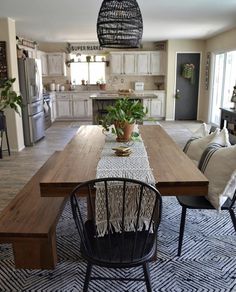 a dining room table with two chairs and a potted plant on top of it