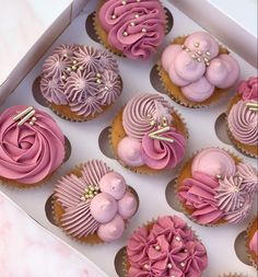 a box filled with pink cupcakes covered in frosting