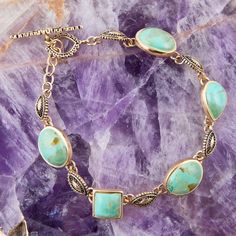 This elegant bracelet boasts genuine bronze and turquoise, with ornate casting details that create a timeless, luxurious look. You'll love the 7.5" length and toggle closure, making it perfect for your special occasions. Experience the beauty of this gorgeous link bracelet! 💍👑 Elegant Patina Bracelets As Gift, Adjustable Elegant Jewelry With Patina Detail, Elegant Turquoise Bracelets With Patina, Elegant Turquoise Bracelet With Patina, Elegant Adjustable Jewelry With Patina, Elegant Turquoise Brass Jewelry, Elegant Bronze Jewelry With Patina, Turquoise Patina Bracelet Jewelry, Turquoise Patina Bracelet