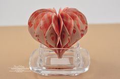 an origami heart in a glass holder