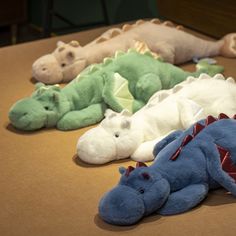 several stuffed animals laying on top of a table next to each other in different colors