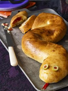 two bagels with googly eyes are on a tray next to a knife