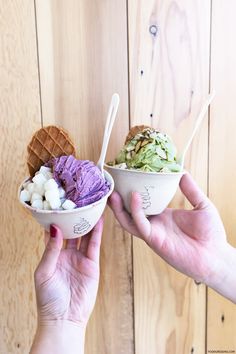 two people holding ice cream cones in their hands