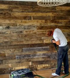 a man using a power washer on a wooden wall