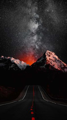 the night sky is filled with stars and bright red lights, as seen from an empty road