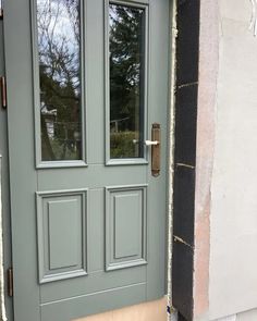 the front door is painted green and has two sidelights on each side, along with a window