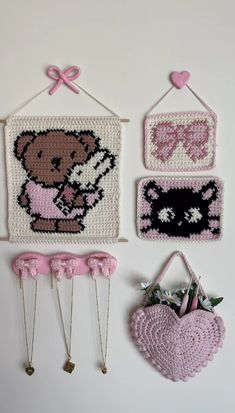 crocheted bears and hearts are hanging on the wall next to other items for decoration