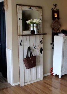 an old white door is holding a basket and flower vases on the top shelf