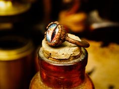 an old fashioned ring sitting on top of a bottle