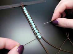 a woman's hands working with beading on a piece of string