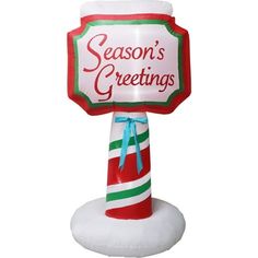 an inflatable sign that says season's greetings on top of a candy cane