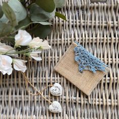 two white and blue stones sitting on top of a woven bag next to some flowers