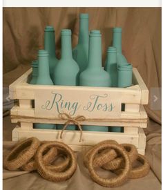 a wooden crate filled with blue bottles sitting on top of a bed covered in burlocks