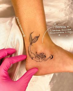 a woman's foot with a small tattoo on the side of her leg and an image of a mermaid