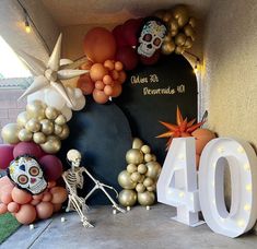 an entrance to a party with balloons and skeleton figurines on the front lawn