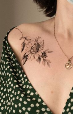 a woman with a sunflower tattoo on her upper arm and chest is wearing a green dress