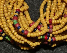 "Royal Jewelry 639. Authentic Konyak Naga Extra Long full mustard belt glass bead \"Royal\" necklace. Mustard beads are most often used in center of special \"Royal\" necklaces or in belts and bibs. The piece is 15 inches long, has 54 strands of mustard colored belt beads and has an old round shell as a closure. It is in excellent condition considering its use and age which is estimated to be early to mid 19th century. Please note that the designation \"Authentic\" means that the piece was made Traditional Yellow Beaded Necklaces With Polished Beads, Traditional Yellow Beaded Necklace With Polished Beads, Traditional Yellow Beaded Necklaces With Tiny Beads, Traditional Yellow Beaded Necklace With Tiny Beads, Traditional Yellow Beads For Jewelry Making, Traditional Yellow Necklace With Tiny Beads, Traditional Yellow Beads, Traditional Yellow Polished Beads, Traditional Yellow Round Beaded Necklaces