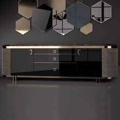 a black and gold sideboard with mirrors on the wall above it in a dark room