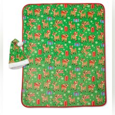 a green christmas blanket with reindeers on it and a white santa's hat