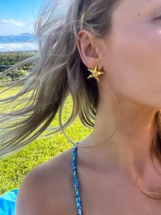 Get ready to shine this summer with our fabulous 18K Gold Plated Starfish Earrings! These beauties are perfect for adding a splash of beach sparkle to any outfit. These earrings are designed to look like adorable starfish, bringing a fun and breezy vibe to your style. Crafted from high-quality gold plating, they're lightweight and comfy, making them ideal for those endless beach days and sunset soirées. Whether you're lounging by the pool or going on a beach vacay, these earrings are your perfec Starfish Jewelry For Vacation, Summer Gold Jewelry With Star Charm, Single Earring For Beach Summer, Gold Star Earrings For Summer, Gold Earrings For Beach Season, Star-shaped Summer Beach Jewelry, Summer Star-shaped Jewelry For Pierced Ears, Star Shaped Earrings For Summer, Star-shaped Beach Jewelry For Beach Season