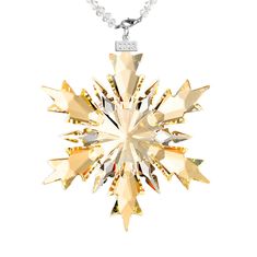 a gold snowflake necklace on a white background