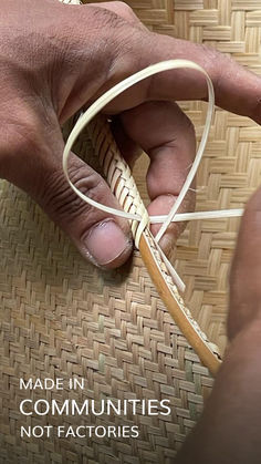 a person holding a piece of woven material with the words made in communities not factories