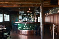 the interior of a restaurant with wooden tables and bar stools