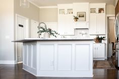 a kitchen with white cabinets and an island in the middle of the room is shown