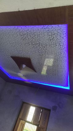 the ceiling is decorated with blue and purple lights, along with a window that has shutters open to let in light