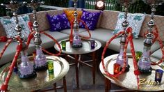 the couches and tables are decorated with wine bottles, candles, and other decorative items