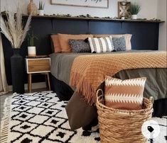 a bedroom with a bed, rugs and baskets on the floor in front of it