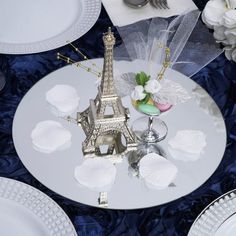 the eiffel tower centerpiece sits on a table set with plates and silverware