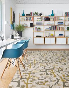 a room with two blue chairs and a book shelf