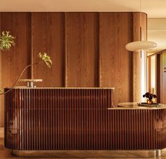 an elegant reception area with wood paneling on the walls and floor, along with potted plants