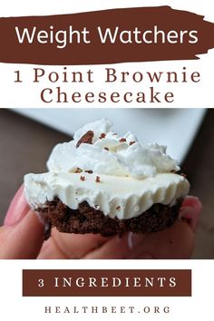 a person holding up a chocolate cupcake with whipped cream on top and the words, weight watchers 1 point brownie cheesecake