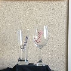 two wine glasses sitting on top of a table next to a framed photo with the words welcome bride and groom