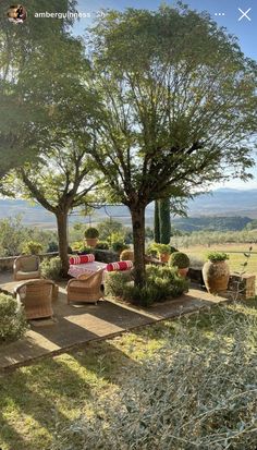 an outdoor patio with wicker furniture and trees