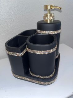 black bathroom accessories set with gold accents on white counter