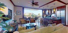 a living room filled with furniture next to a kitchen and an open concept dining area