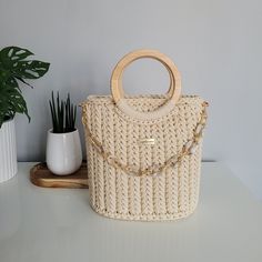 This is luxury handmade crochet bag with wooden handles. This bag model is perfect for everyday use, fits many styles and holds the most necessary things. The set includes a chain with leather cushioning on the shoulder. Is accessorie for elegant and fashion women.  This bag is made with top quality poliester yarn and natural leather.  This bag is made with a leather bottom, inside is cotton linnig with pocket. I create handicrafts with passion and heart! Bag's dimensions-): Width: 24cm Height: 25cm (without handles) Depth: 14cm Chain lenght: 100cm or 120cm Material: Polyester yarn and natural leather. Color: Cream with gold fittings and beige leather. In set is chain on shoulder 100cm or 120cm. I make the bag to order. Order processing time is approximately 1-3 weeks + shipping time. Crochet Bag With Wooden Handles, Bag With Wooden Handles, Elegant Handbag, Handmade Crochet Bags, Trunk Bag, Chain Handbag, Bag With Chain, Elegant Bags, Bag Model