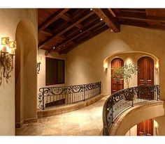 a staircase leading to the upper level of a house with wood and wrought iron railings