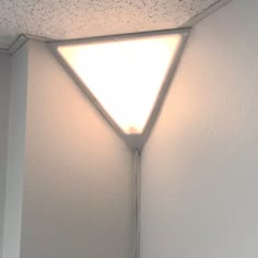 a light that is on the side of a wall in a room with white walls