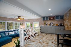 a living room filled with furniture next to a kitchen and dining room table on top of a hard wood floor